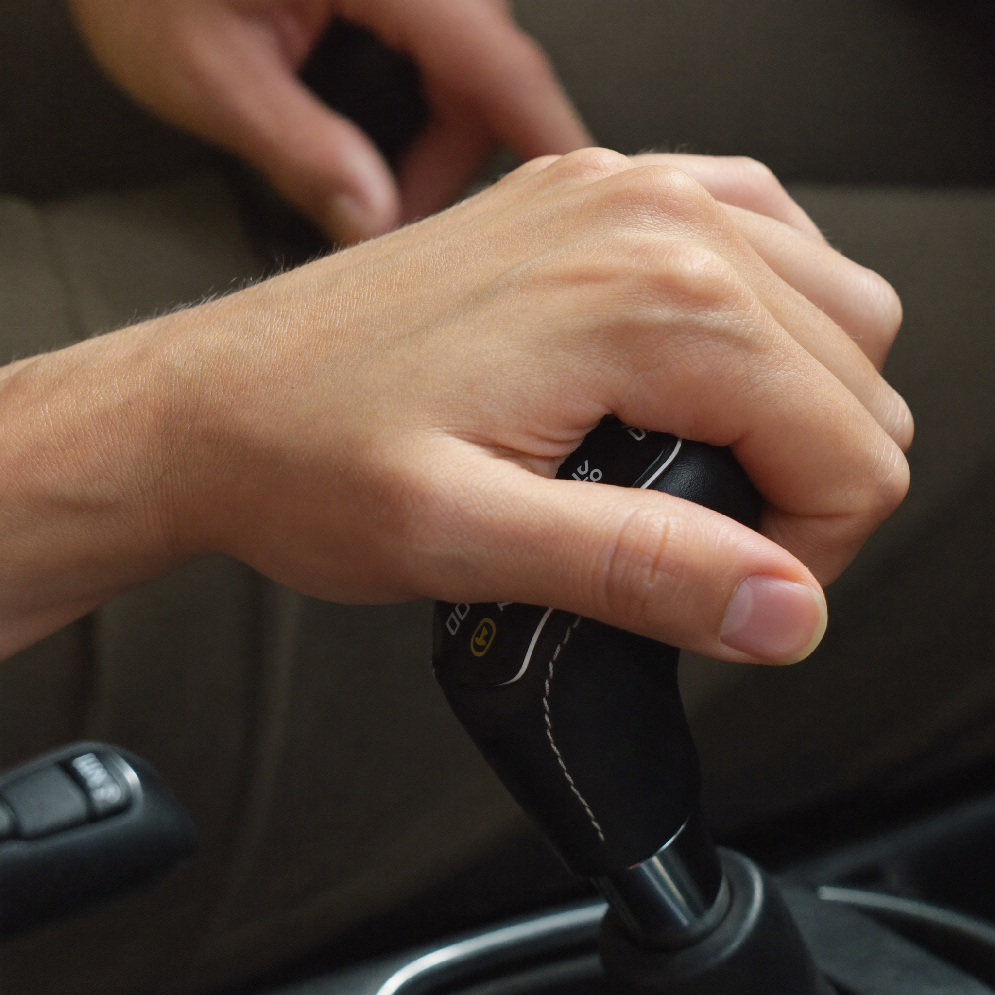 Hand op de versnellingspook van een schakel-lesauto